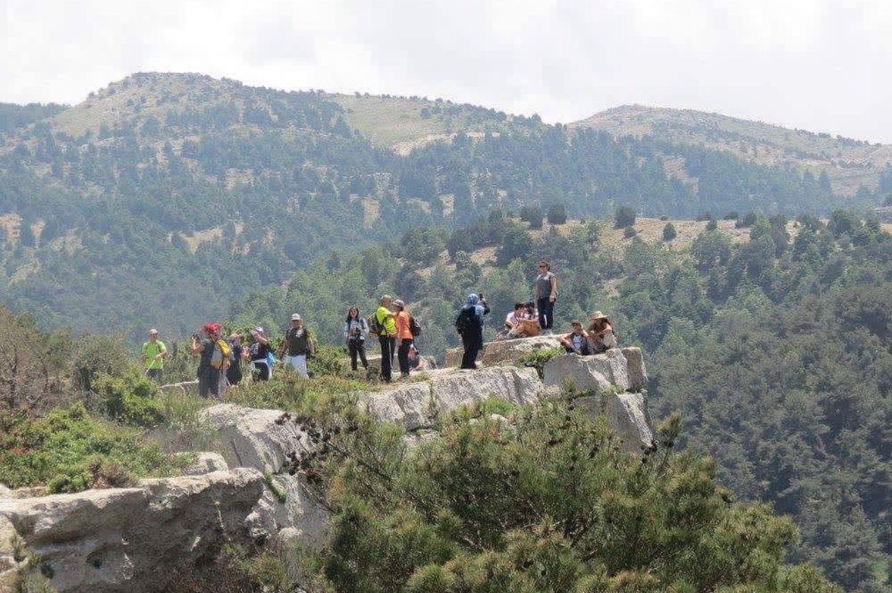 * Group of hikers walking along a scenic trail during sunset in Kobayat. * Caption: Sunset hikes through Kobayat’s peaceful mountain trails offer unforgettable moments in nature.