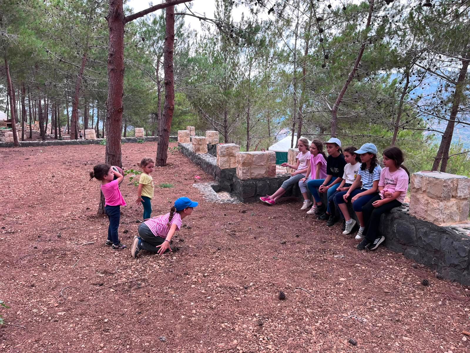 Children playing outdoor games together in the pine forest at Horizon Pines in Kobayat, Akkar, Lebanon.