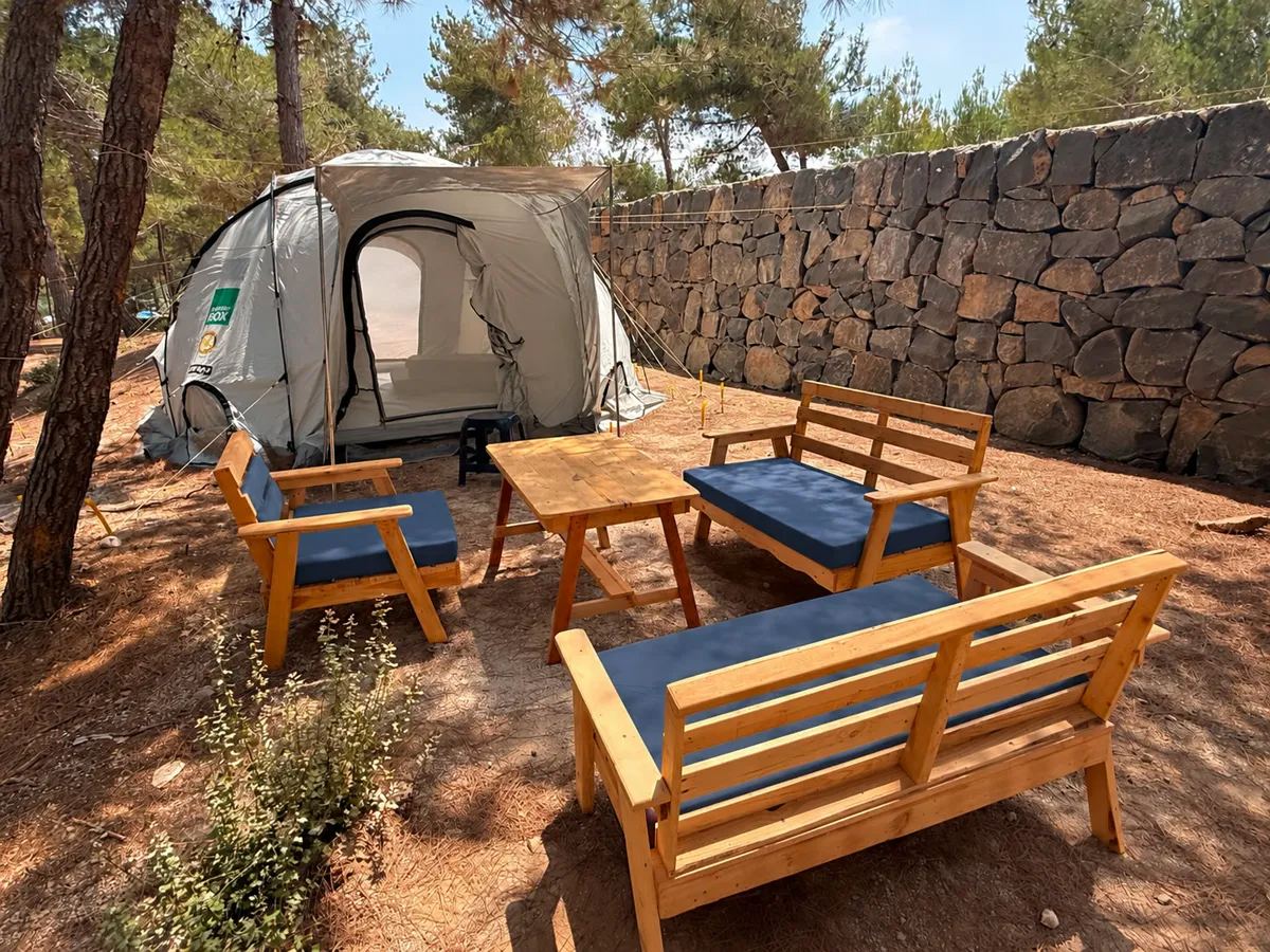 A family camping pitch beside a dry-stone wall at Horizon Pines