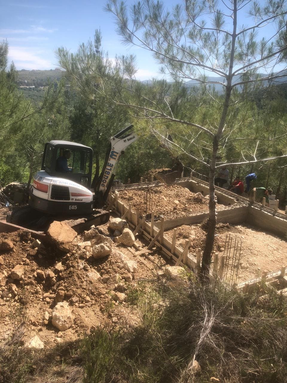 Excavator working on hillside foundation preparation at Horizon Pines, Lebanon