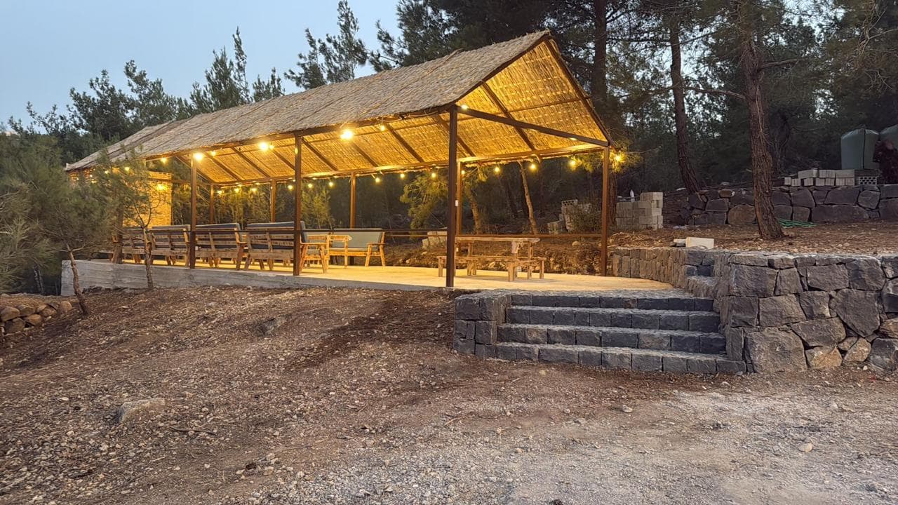 Outdoor dining and lounge area with warm evening lights at Horizon Pines campsite in Lebanon