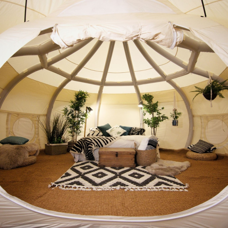 Interior of a Lotus Belle glamping tent at Horizon Pines in Lebanon, featuring cozy rugs, plants, and natural light filtering through the dome roof.