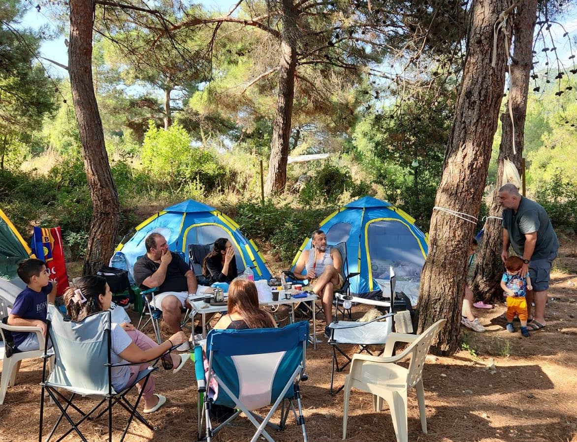 Group of young campers enjoying a sunny day hiking and bonding at Horizon Pines in Lebanon, surrounded by tall pine trees and nature.