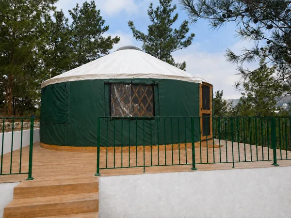 The yurt from outside, on its timber deck among the pines
