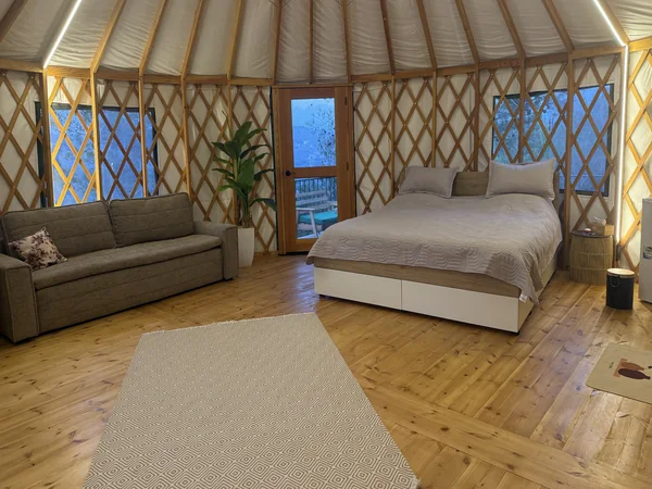 The yurt at night, warm LED lighting along the roof beams