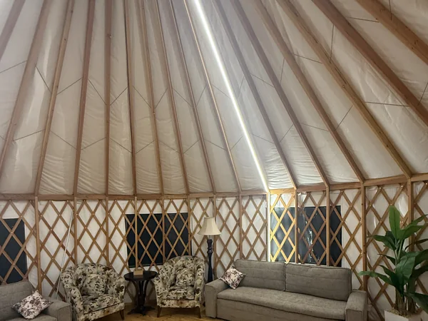 Inside the yurt, made-up bed against the lattice wall